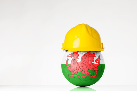 still life image of football wearing a hard hat with the Wales flag  superimposed on the footballの写真素材