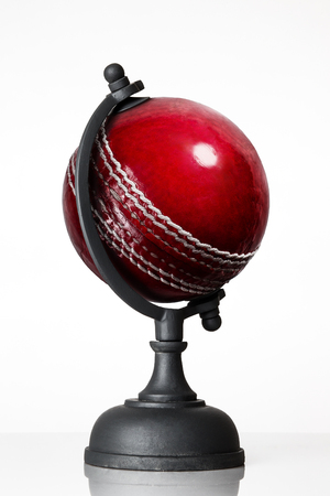 still life image of cricket ball world globe on whiteの写真素材