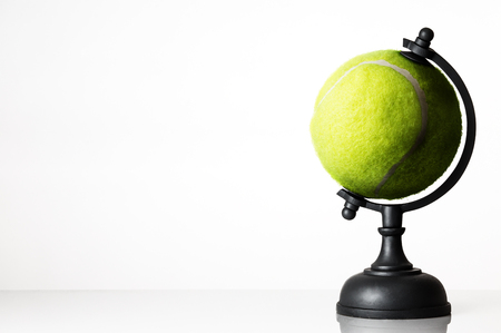 still life image of tennis ball world globe on whiteの写真素材