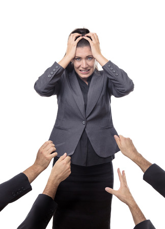 business woman being pulled down by hands all around herの写真素材