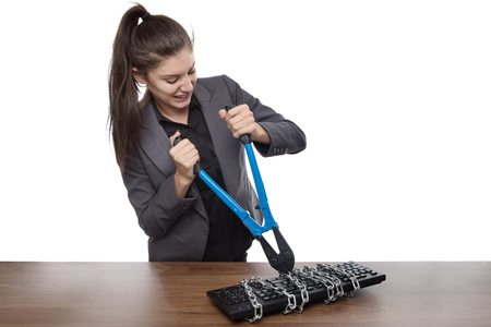 Computer keyboard locked up and business woman with bolt cutters trying to set it freeの写真素材