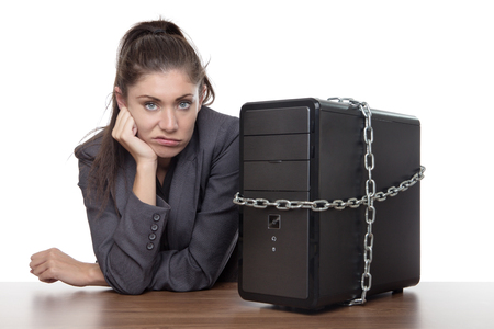 Computer locked up and business woman not looking very happy unsure what to do.の写真素材