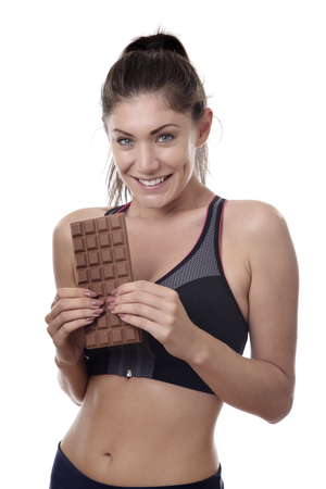 fitness woman holding a chocolate barの写真素材