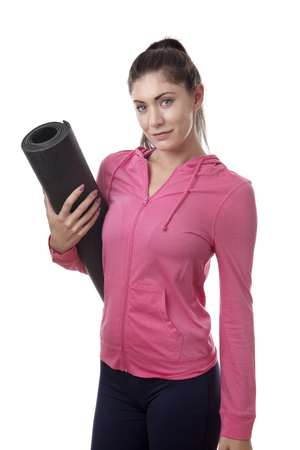 young happy woman holding a yoga mat under her armの写真素材