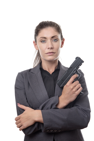 business woman holding a gun looking at cameraの写真素材