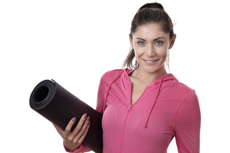 young happy woman holding a yoga mat under her armの写真素材