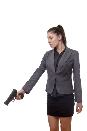 business woman pointing a gun down at something on the groundの写真素材