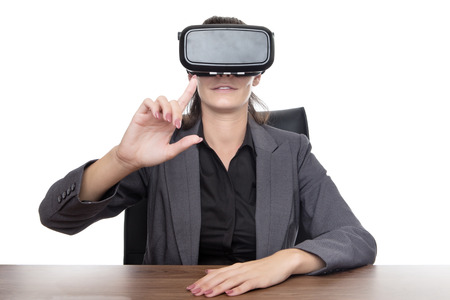 business woman sitting at desk working using a vr headsetの写真素材