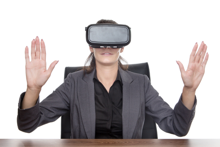 business woman sitting at desk working using a vr headsetの写真素材
