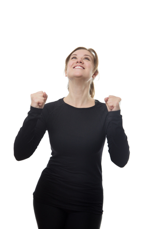 happy excited fitness woman all in black with her hands up in the airの写真素材