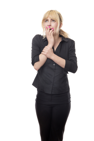 blonde haired business woman standing looking around scaredの写真素材