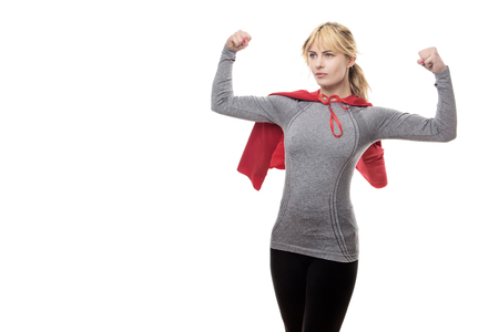 blonde haired fitness woman wearing a grey top and a superhero capeの写真素材