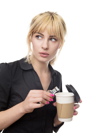 blonde haired business woman putting alcohol into her take away cupの写真素材