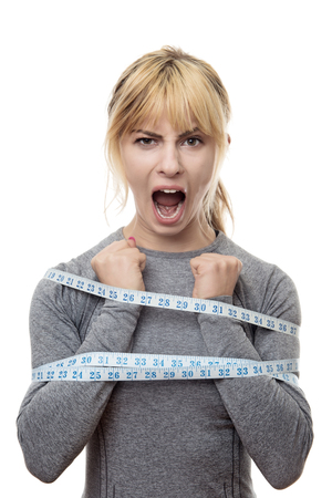 blond haired woman with a tape measure around her trying to break free from your restraintsの写真素材