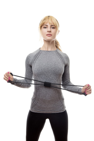 blonde haired woman wear a grey sports top using a rubber band for resistance trainingの写真素材