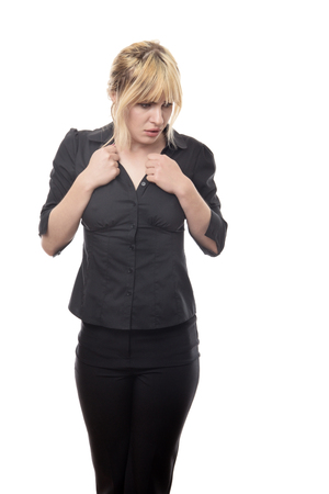 blonde haired business woman standing looking around scaredの写真素材
