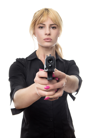 blonde haired business woman pointing a gun at the cameraの写真素材