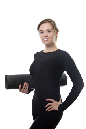 fitness woman all in black holding a yoga matの写真素材