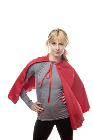 blonde haired fitness woman wearing a grey top and a superhero capeの写真素材