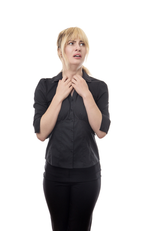 blonde haired business woman standing looking around scaredの写真素材