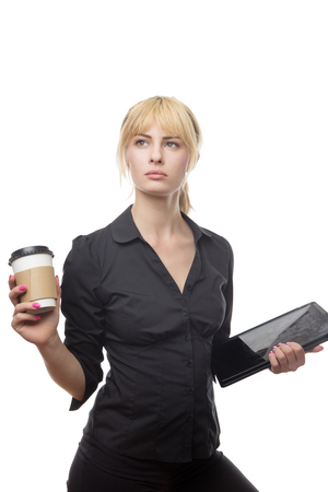 standing blonde haired business woman holding a coffee cup and a computerの写真素材