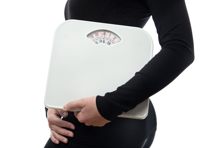 claose up shot of fitness woman wearing black holding a set of scales の写真素材