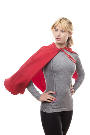 blonde haired fitness woman wearing a grey top and a superhero capeの写真素材