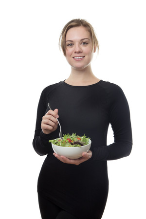 happy fitness woman all in black eatting a saladsの写真素材