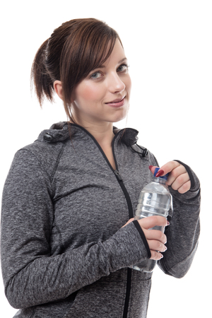 standing fitness woman wearing a tracksuit drinking waterの写真素材