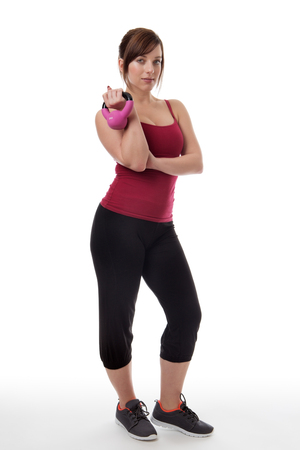 standing fitness woman working out holding a kettlebelの写真素材