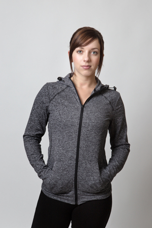 standing fitness woman wearing a tracksuit looking at cameraの写真素材