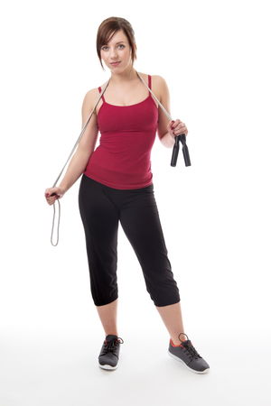 shot in the studio of young fitness woman with a skipping rope around her neck の写真素材
