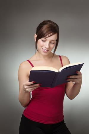 shot in the studio of young fitness woman reading a bookの写真素材