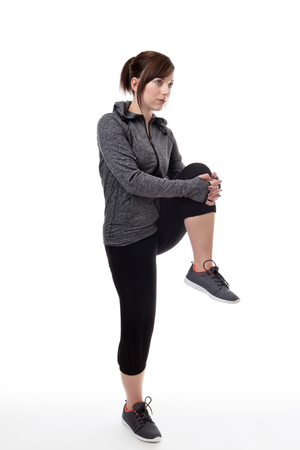 fitness woman wearing a tracksuit stretching her legsの写真素材