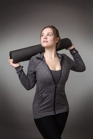 young fitness holding a yoga matの写真素材
