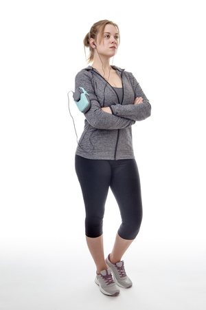 female fitness model listening to music on her mobile phoneの写真素材