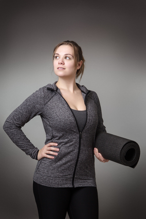 young fitness holding a yoga matの写真素材