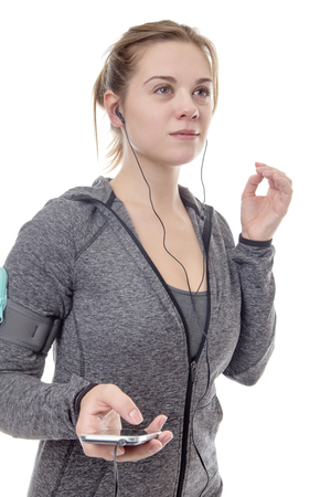 female fitness model listening to music on her mobile phoneの写真素材