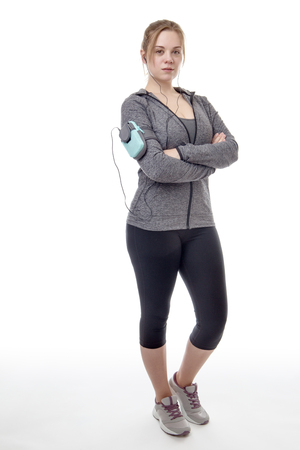 female fitness model listening to music on her mobile phoneの写真素材