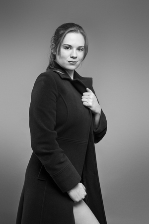 sexy woman wearing a coat and just her underwear shot in the studioの写真素材