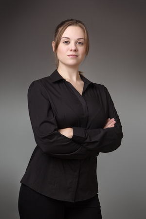 young standing business woman shot in the studio on a grey backgroundの写真素材