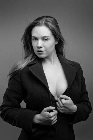 sexy woman wearing a coat and just her underwear shot in the studioの写真素材