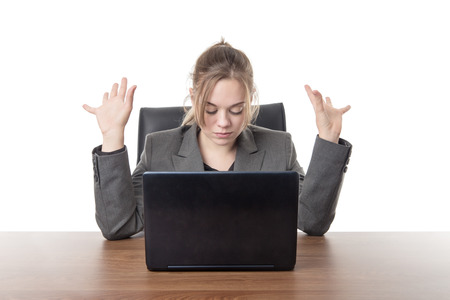 business woman sitting a a desk with a laptop computer in front of her の写真素材