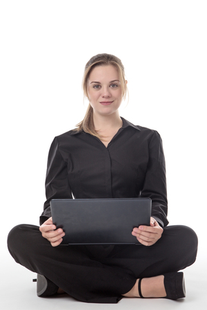 happy business woman sitting on the floor using a laptop computerの写真素材