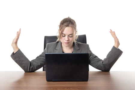 business woman sitting a a desk with a laptop computer in front of her の写真素材