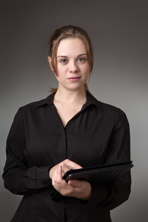 young business woman using a computer shot in the studio on a grey backgroundの写真素材