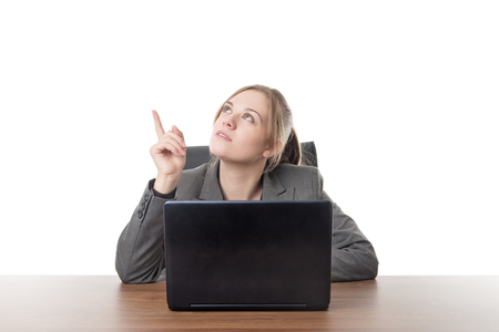 business woman sitting a a desk with a laptop computer in front of her の写真素材