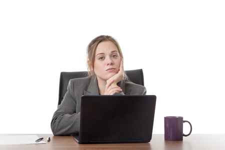business woman sitting a a desk with a laptop computer in front of her の写真素材