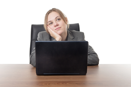 business woman sitting a a desk with a laptop computer in front of her の写真素材
