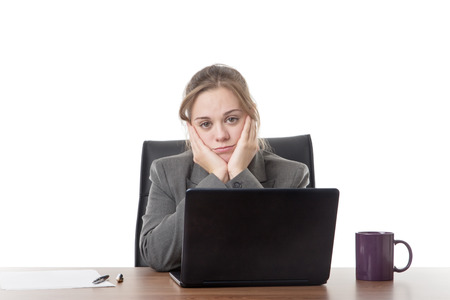 business woman sitting a a desk with a laptop computer in front of her の写真素材